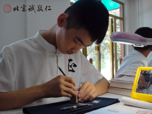 
篆刻班小學員在認真專注的習練篆刻
